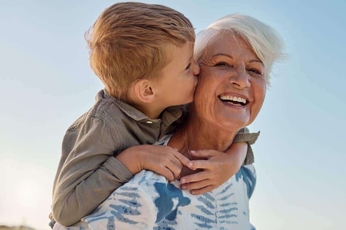 Grandmother smiling while holding her grandchild, representing invisalign clear aligner treatment at tuckahoe creek dental in richmond, va.