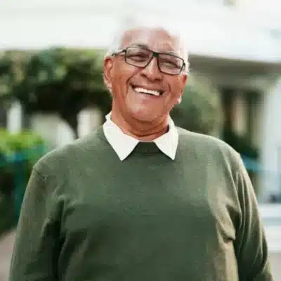 Same-day cerec crowns 3 Older man smiling in green dress shirt, representing same day cerec crowns